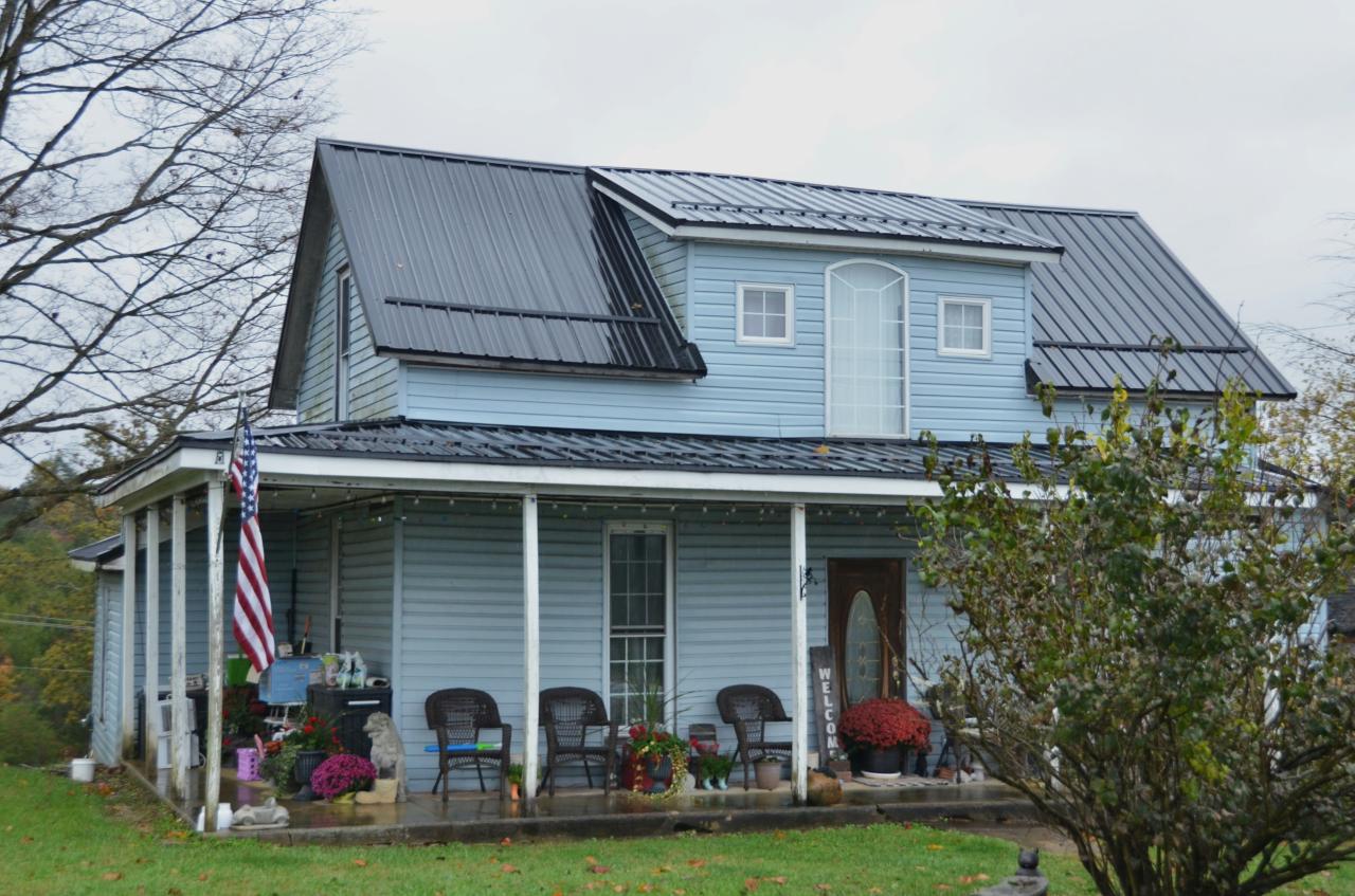 A light blue house with a large porch.
